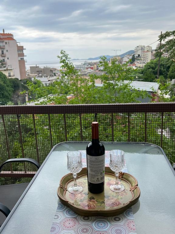a bottle of wine sitting on a table with two glasses at VALANTIS APARTMENT in Kavála