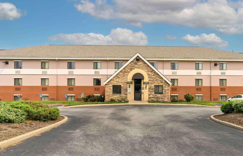 a large building with a parking lot in front of it at Suburban Studios Louisville East in Louisville