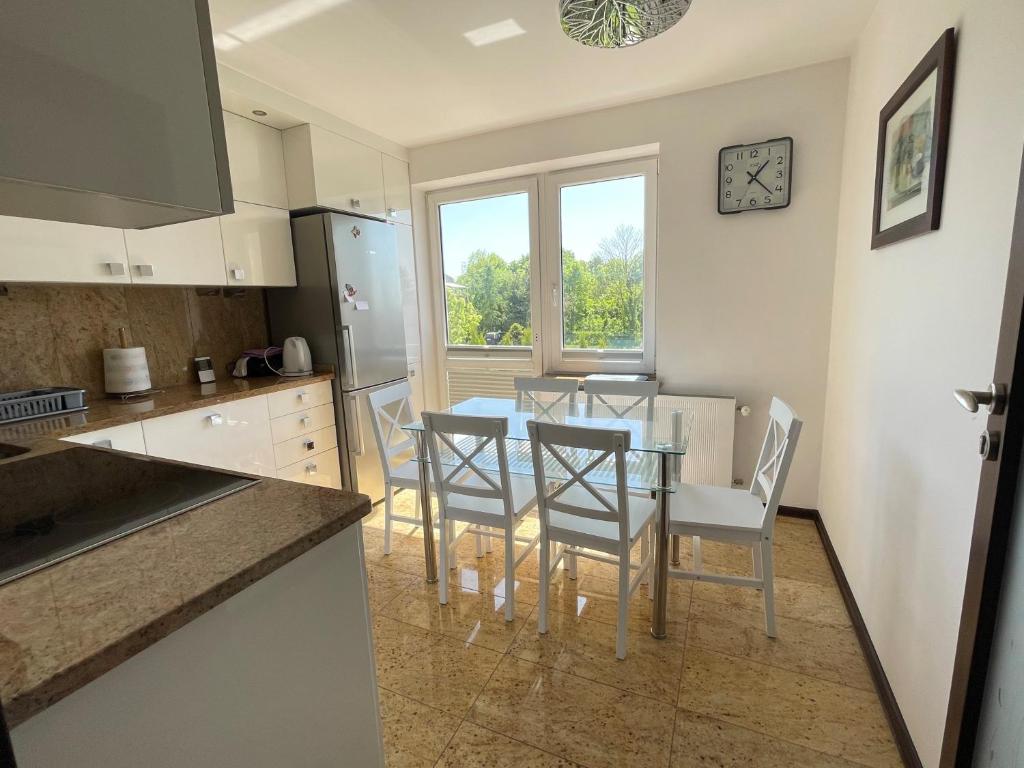 a kitchen and dining room with a table and chairs at Marble Apartament in Zamość