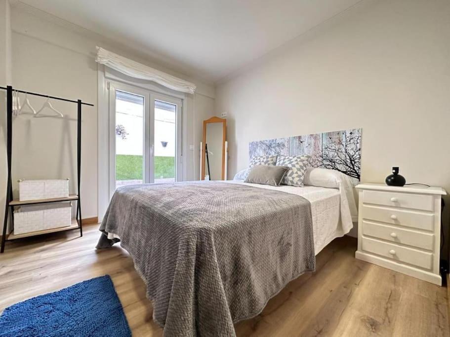 1 dormitorio con 1 cama grande con alfombra azul en Amplio apartamento con terraza en Bouzas, cerca de la playa., en Vigo