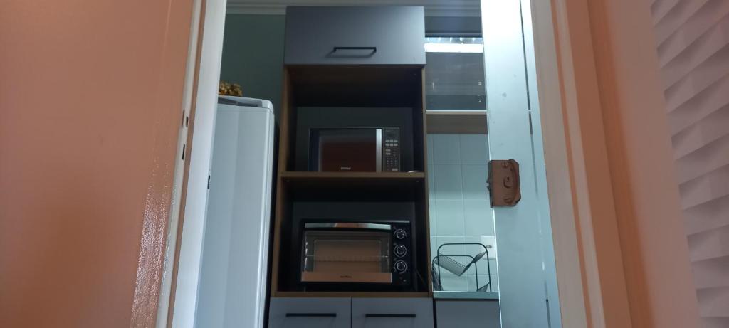 a kitchen with a refrigerator and a microwave at Espaço aconchegante em Criciúma in Criciúma
