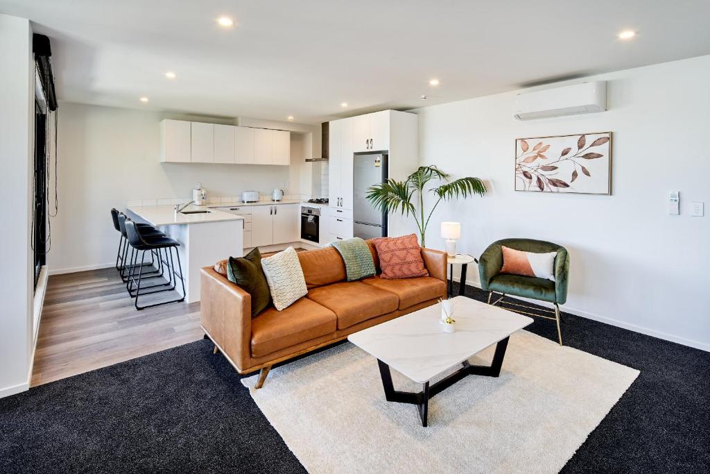 sala de estar con sofá y mesa en Brand New with Ocean Views en Wellington