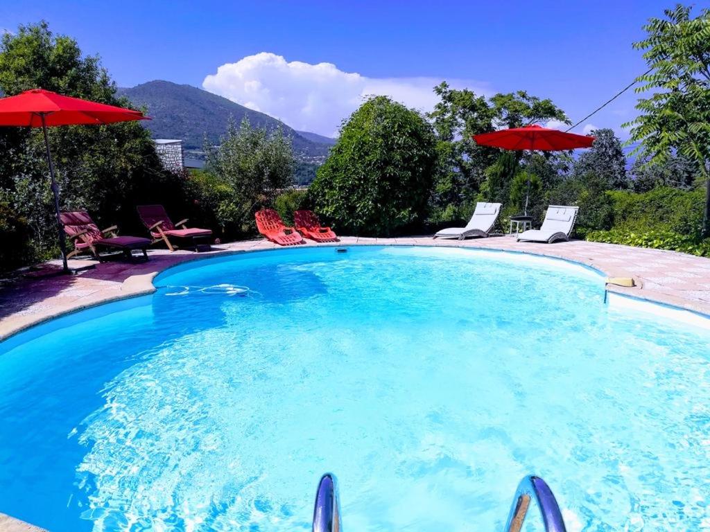 uma grande piscina com cadeiras e guarda-sóis em Villa Côte d'Azur piscine privée em La Gaude