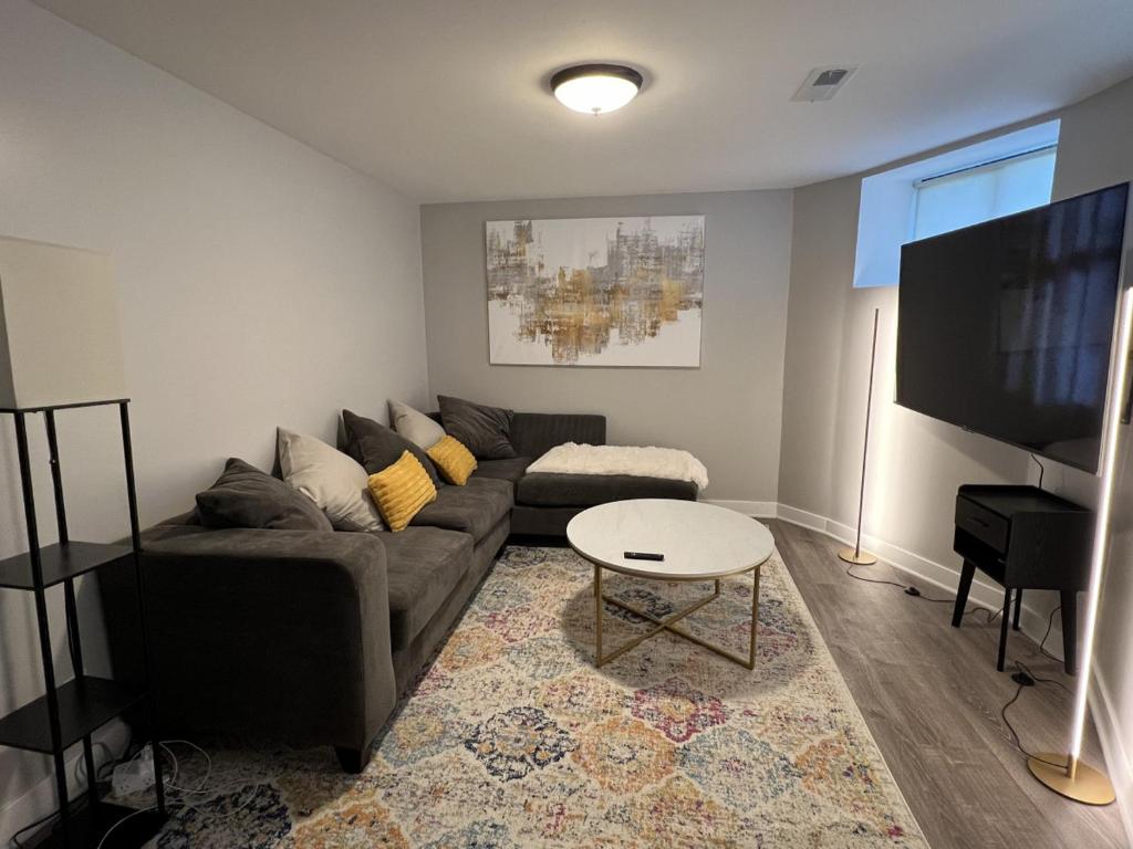 ein Wohnzimmer mit einem Sofa und einem Flachbild-TV in der Unterkunft Modern 3 Bedroom Close to Downtown Chicago in Chicago