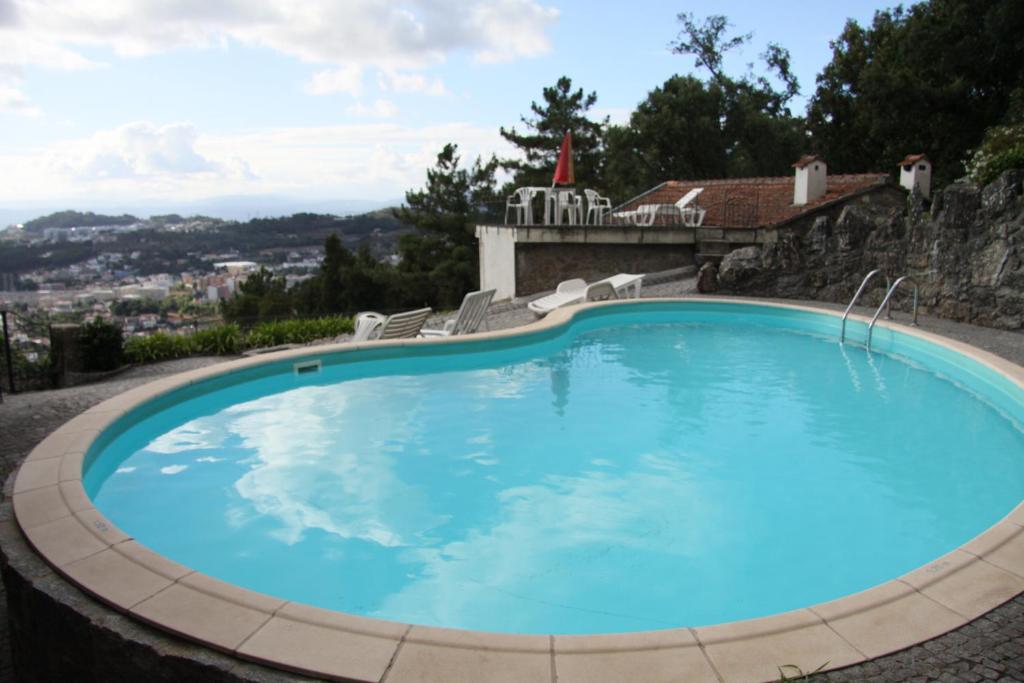 a large blue swimming pool with chairs around it at Casa dos Lagos - Braga in Braga