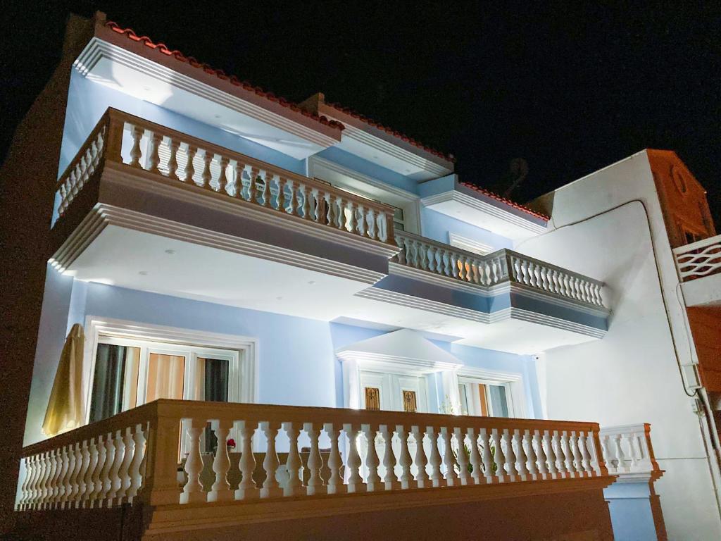 a white building with a white railing and a balcony at Beach Blue Villa in Korinthos
