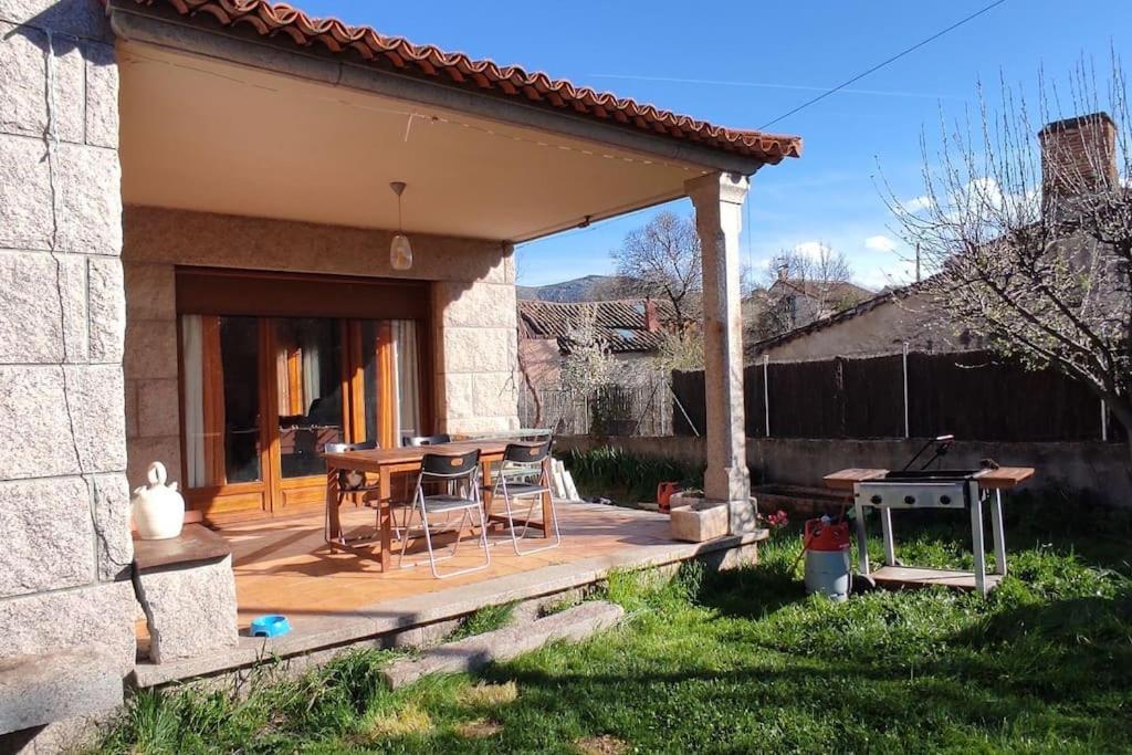patio con mesa y sillas en La casa del fresno, en Pinilla del Valle