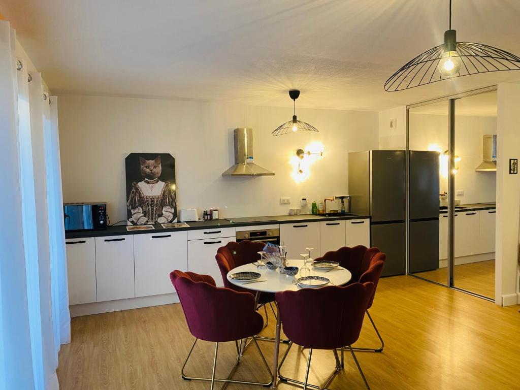 een keuken met een tafel en stoelen en een koelkast bij Lisandrina in Ajaccio