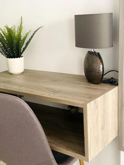 een houten bureau met een lamp en een plant erop bij Comfort and relaxation in Piraeus