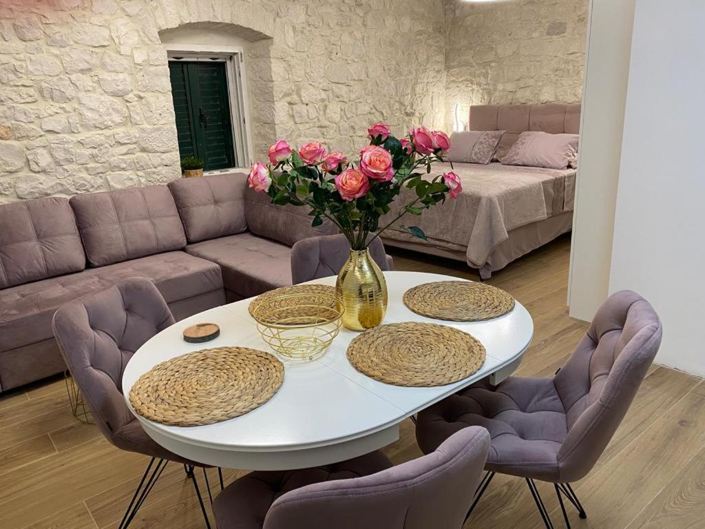 una mesa blanca con un jarrón de flores en la sala de estar en Garma en Slatine