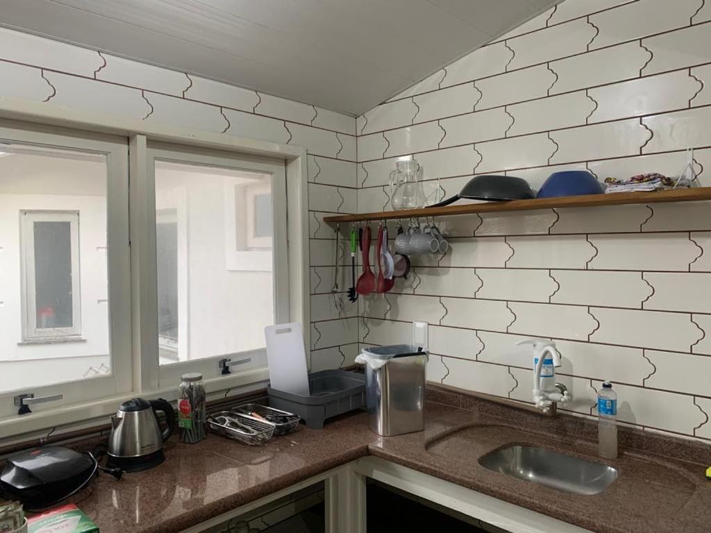 un comptoir de cuisine avec un évier et une fenêtre dans l'établissement Apartamento próximo ao Aeroporto de Florianópolis, à Florianópolis