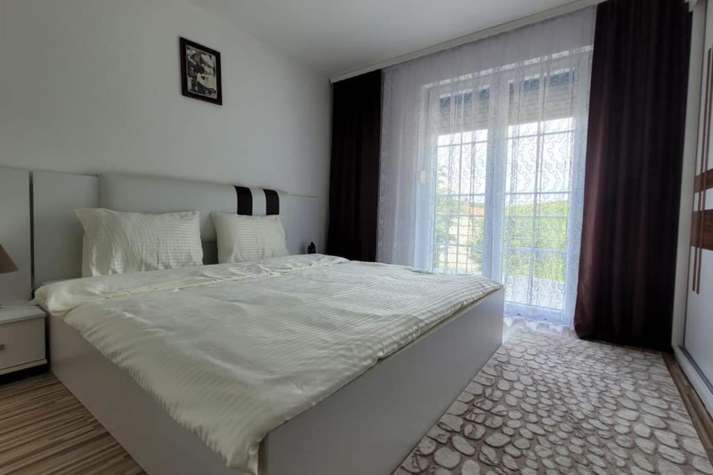 una camera da letto con un grande letto bianco e una finestra di Amazing Villa with pool nearby Shtime - Ferizaj a Ferizaj