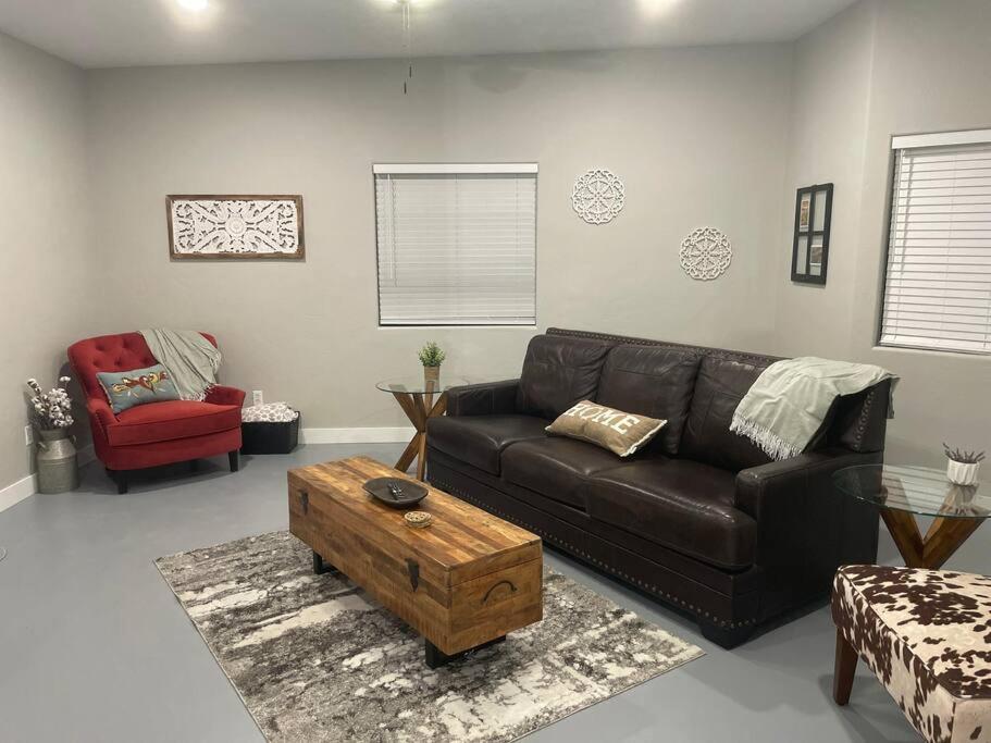 a living room with a leather couch and a coffee table at Desert Ranch Home 3 Bedroom + Equine Facility in Vail