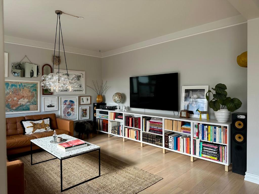 ein Wohnzimmer mit einem Flachbild-TV auf einem Bücherregal in der Unterkunft Bright and Spacious 4 bedroom apartment in Hlíðar, Reykjavik in Reykjavík