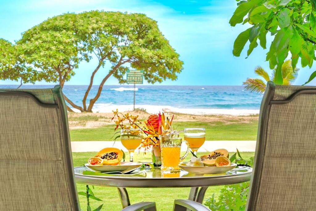a table with food and drinks on the beach at Islander Resort Oceanfront # 149 in Kapaa