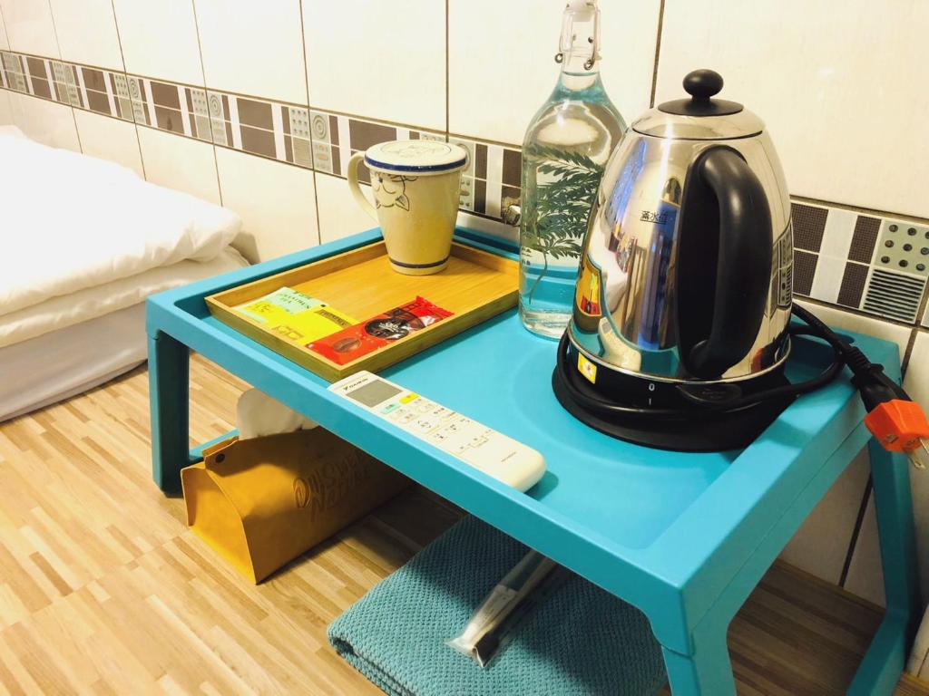 a blue table with a tea kettle on top of it at Fish Hostel in Yingge