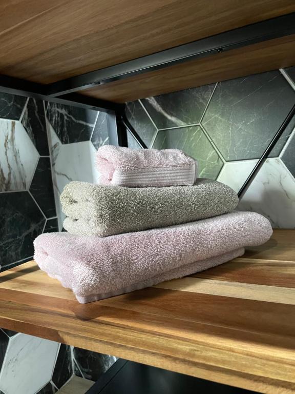 three towels sitting on a shelf in a bathroom at Cense AB in Saint-Amand-les-Eaux