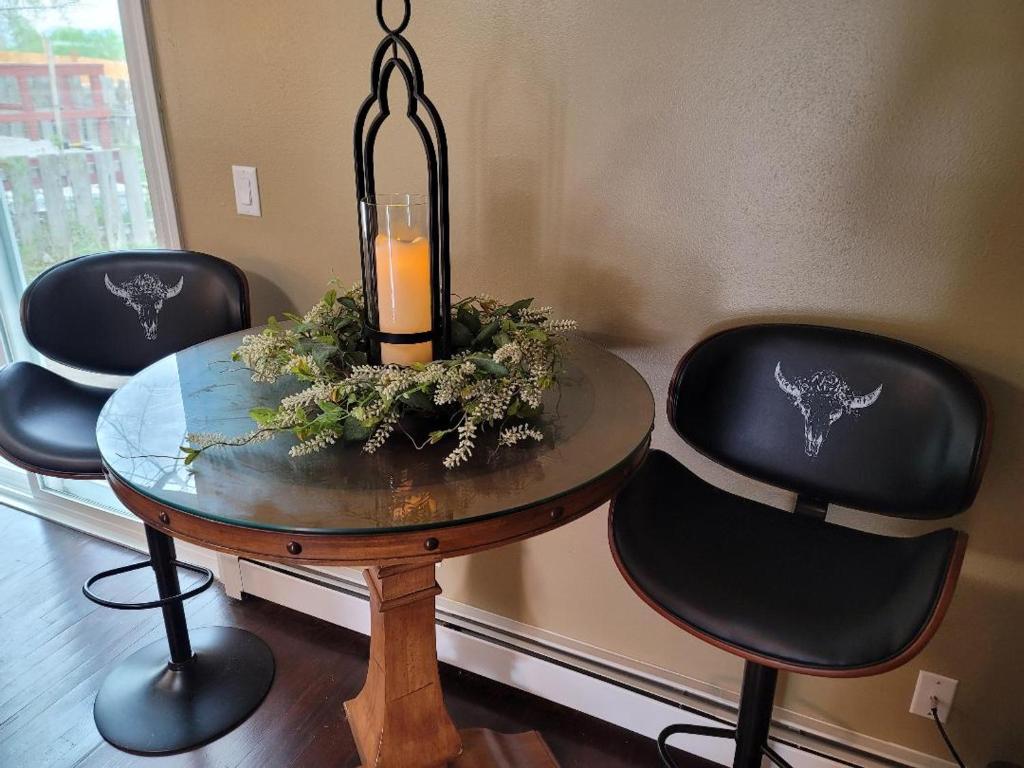 uma mesa com duas cadeiras e uma vela sobre ela em Mountain View Lodging Cody em Cody