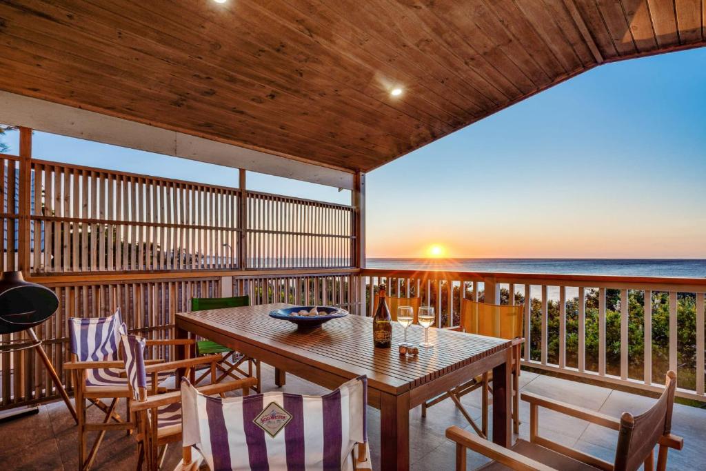 a deck with a table and chairs and a view of the ocean at Waters Edge in Frankston