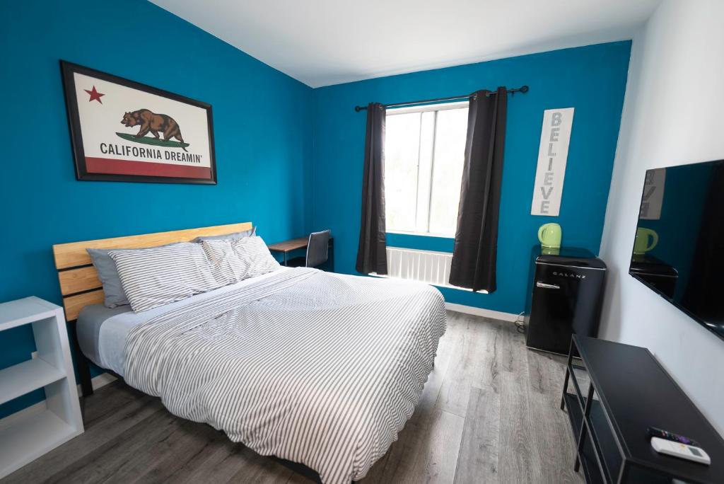 - une chambre avec un lit et un mur bleu dans l'établissement Cozy Hollywood Get Away, à Los Angeles