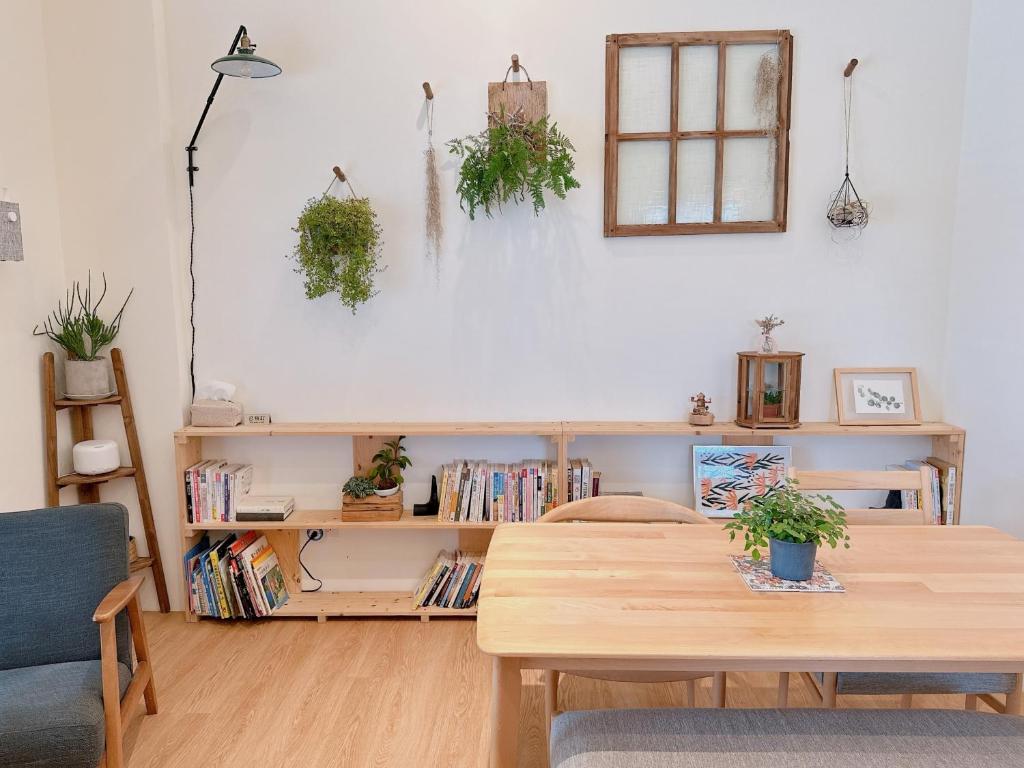 una sala de estar con una mesa de madera y una estantería de libros. en Gardenstay, en Luodong