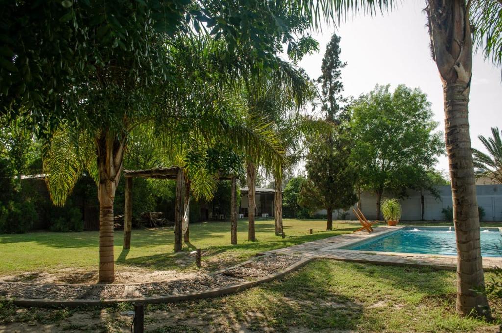 un complejo con piscina y palmeras en Complejo Mis Pumitas en La Banda