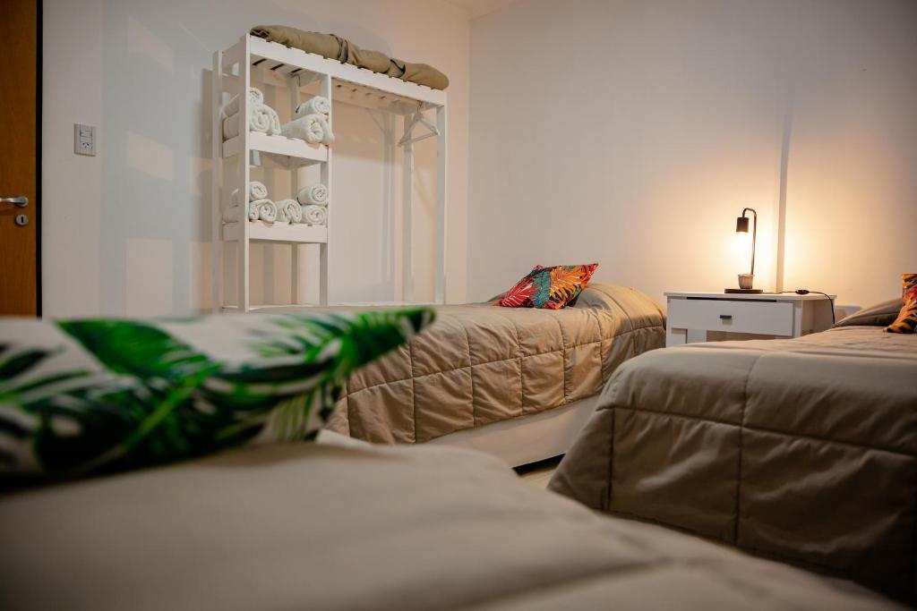拉巴斯的住宿－La Boya Departamentos，一间设有两张床的房间和一个配有盘子的架子