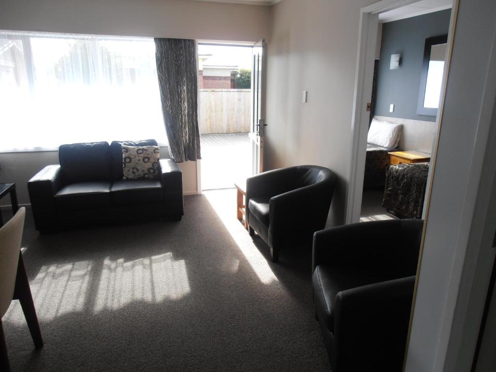 a living room with a couch and chairs and a window at Comfort Inn Tayesta Motel in Invercargill