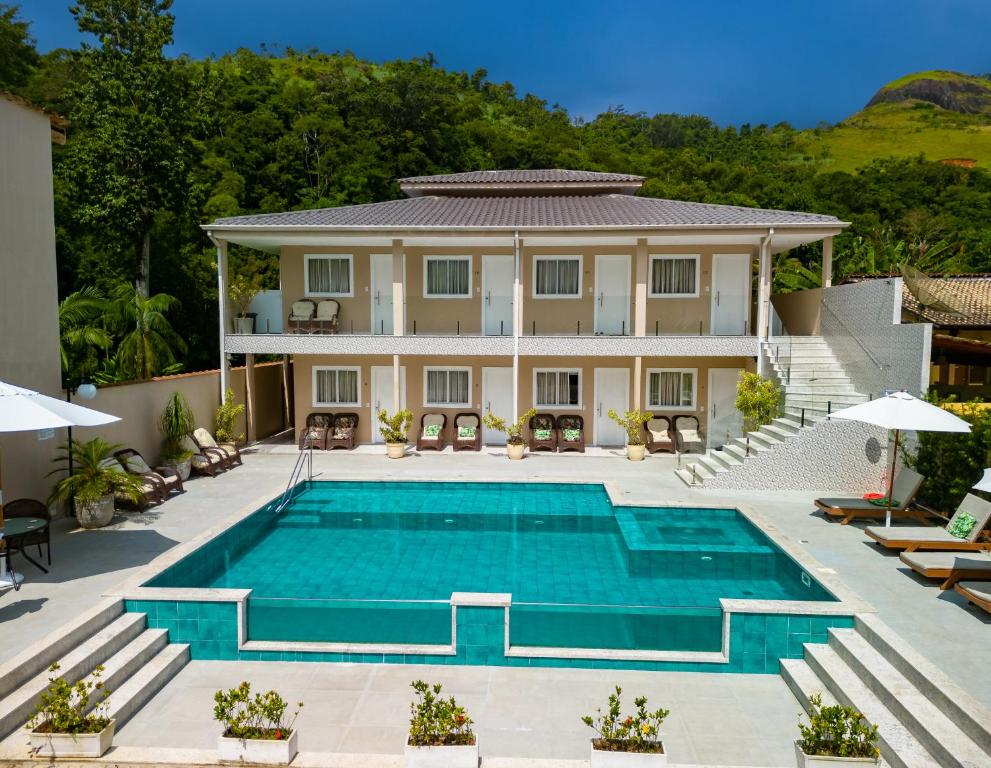 une villa avec une piscine en face d'une maison dans l'établissement POUSADA HAPPY DAY PARATY, à Parati