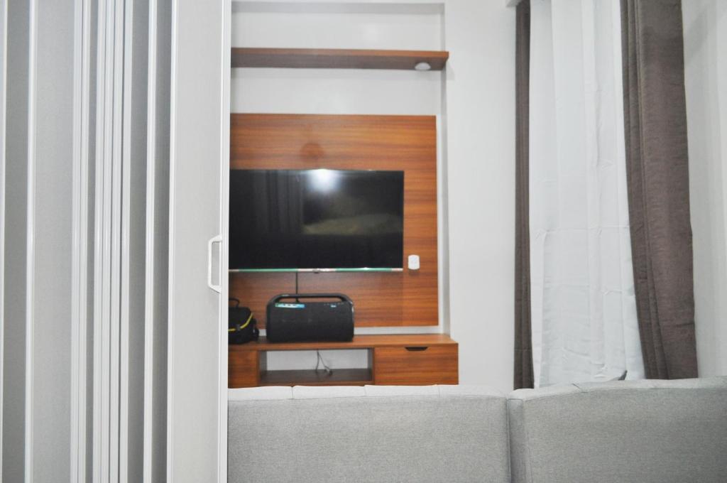 a living room with a tv on a wall at Apparate Condotel Staycation in Cavite