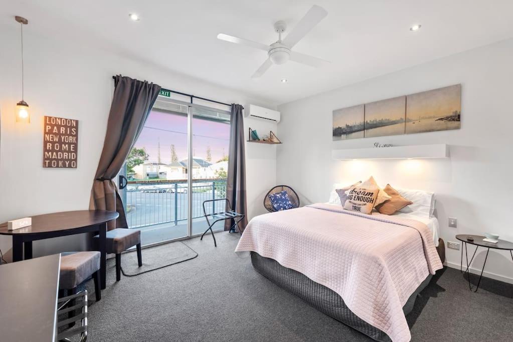 a bedroom with a bed and a desk and a window at Scarborough beach break holidays - Unit 2 in Scarborough
