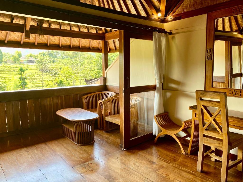 a room with a table and chairs and a window at Abian Ayu Villa in Sidemen