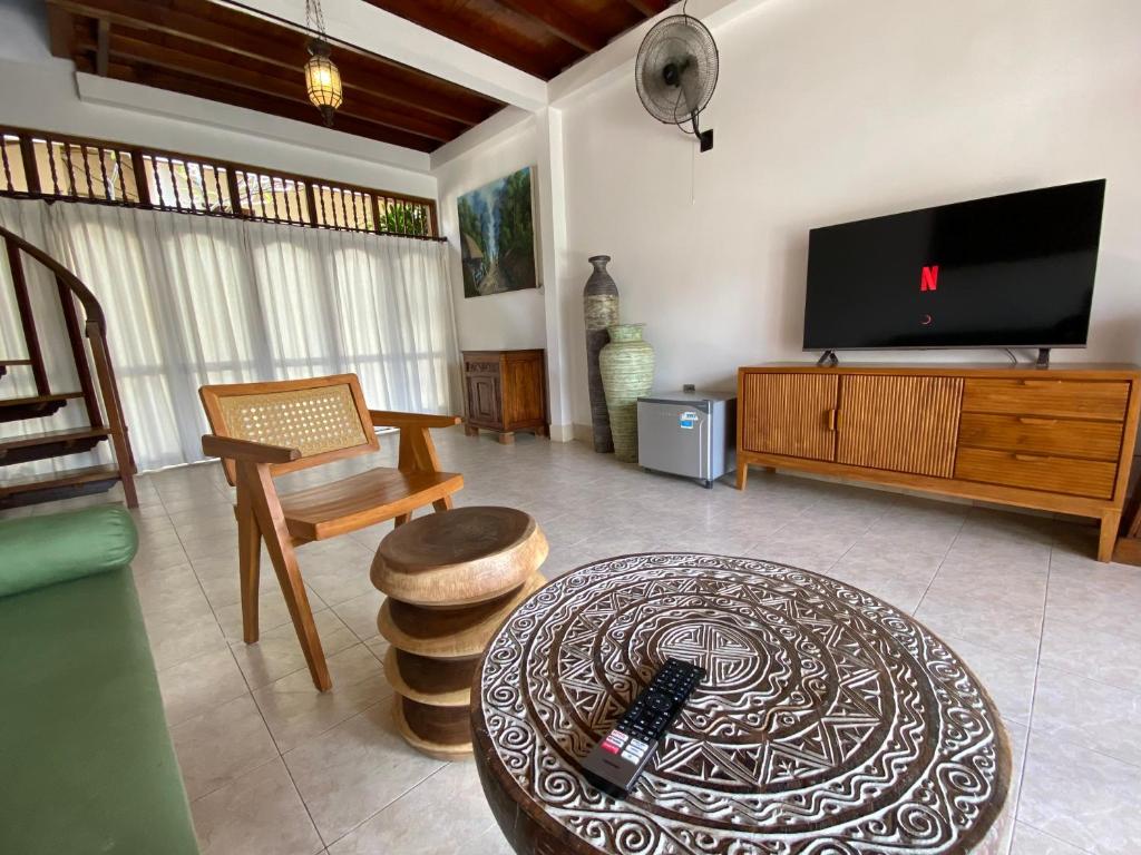 a living room with a tv and a coffee table at Abian Ayu Villa in Sidemen