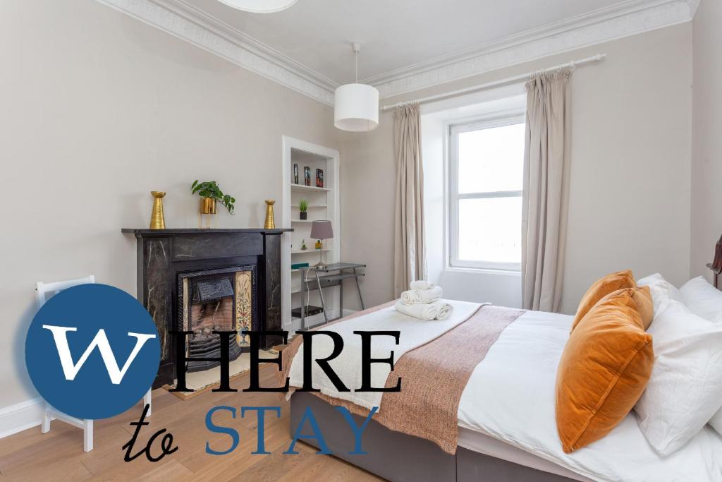 1 dormitorio con 1 cama y chimenea con las palabras hogar para alojarse en Bright 2 bed apartment by Rodney st en Edimburgo
