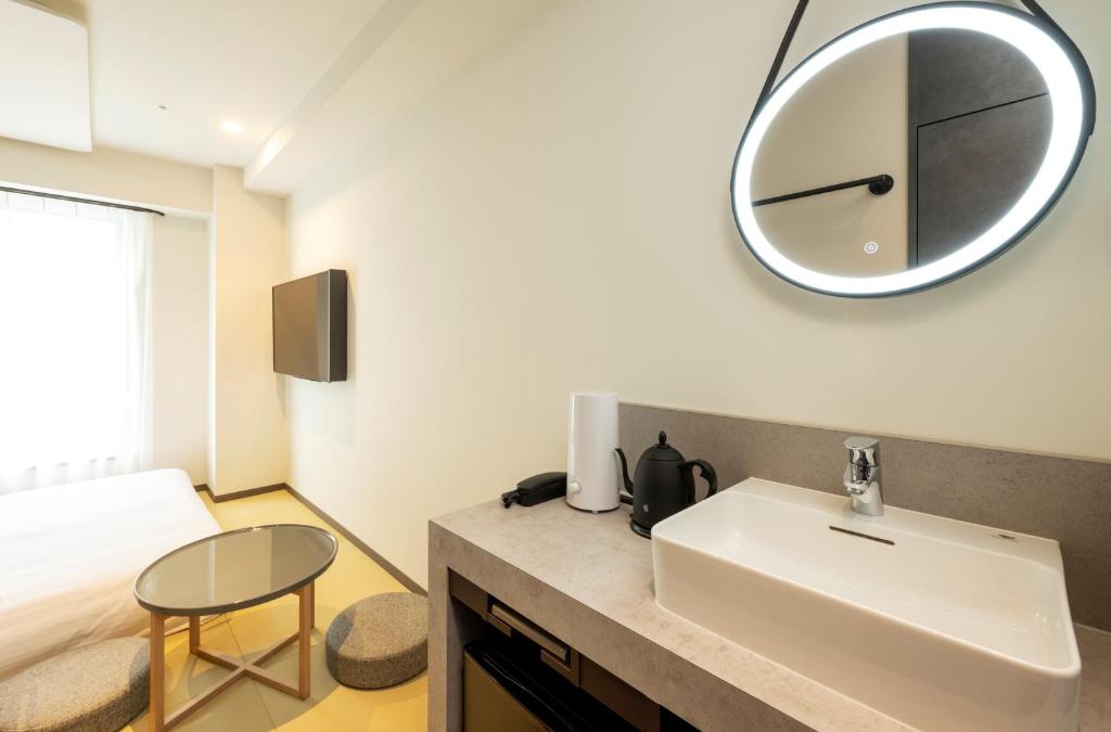 東京的住宿－HOTEL AMANEK Shinjuku Kabukicho，浴室设有水槽和墙上的镜子