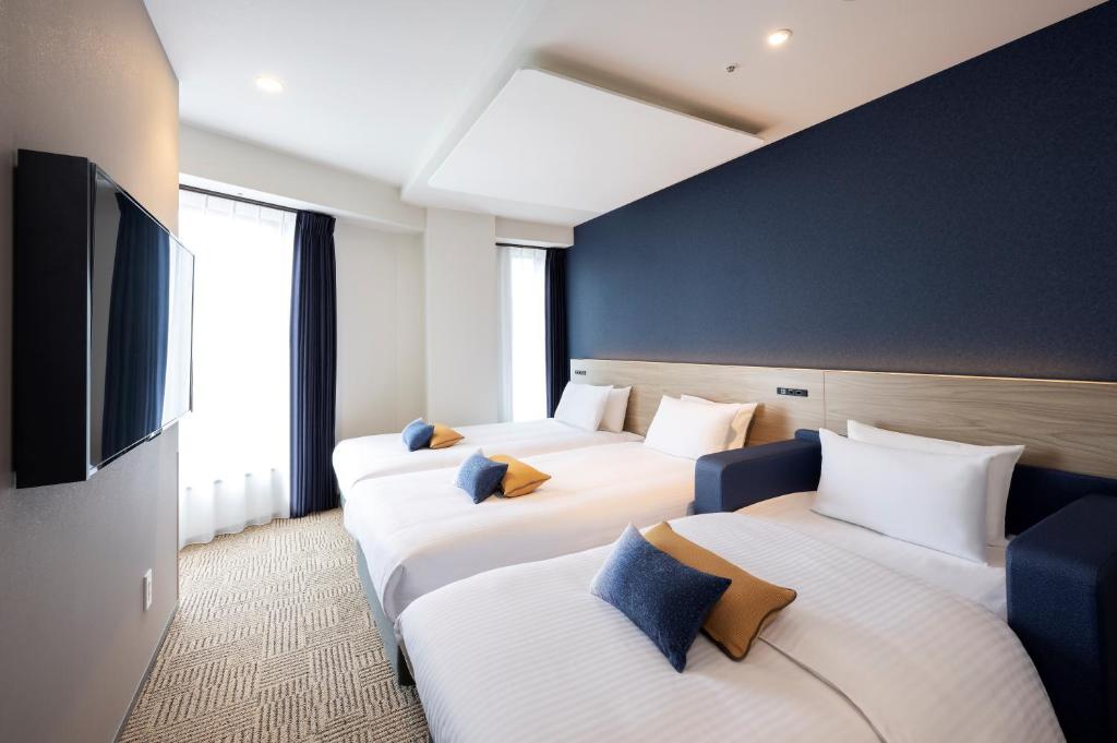 Postel nebo postele na pokoji v ubytování HOTEL AMANEK Shinjuku Kabukicho