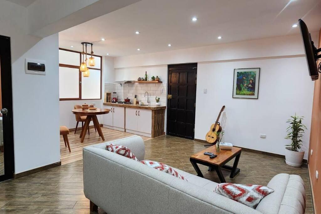 uma sala de estar com um sofá, uma mesa e uma cozinha em Departamento Cumbe Mayo em Cajamarca