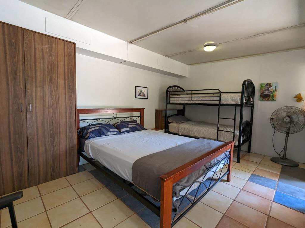 a bedroom with a bed and two bunk beds at Broome Bird Observatory in Broome