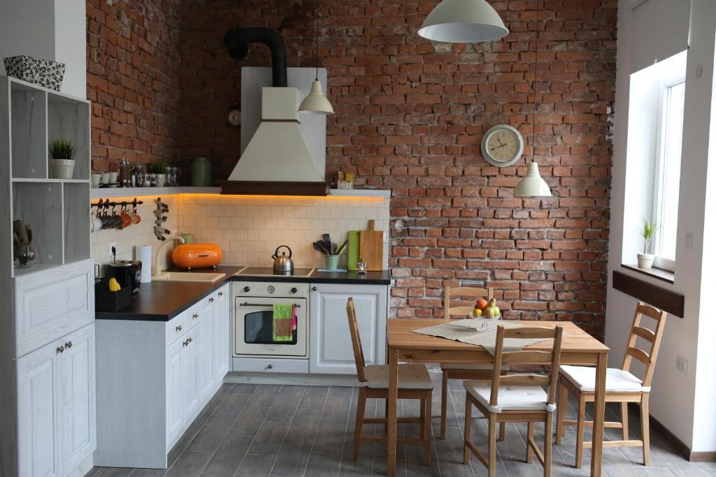 a kitchen with a table and a brick wall at Del Toro Apartment in Skopje