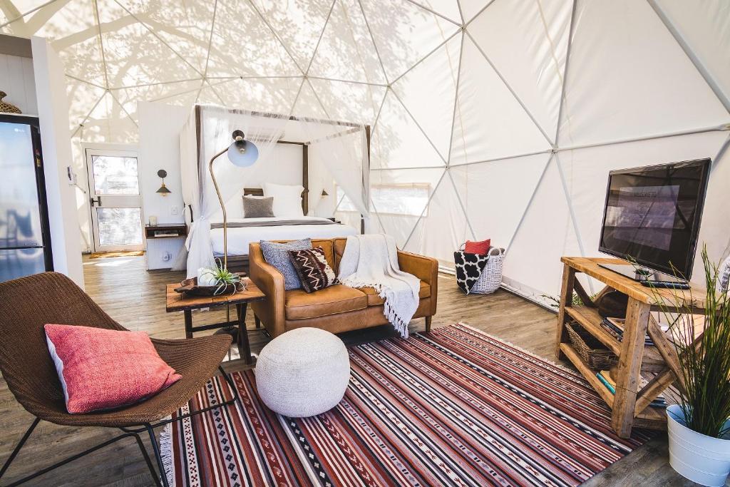 um quarto com uma cama, um sofá e uma televisão em Faraway Domes em Warialda