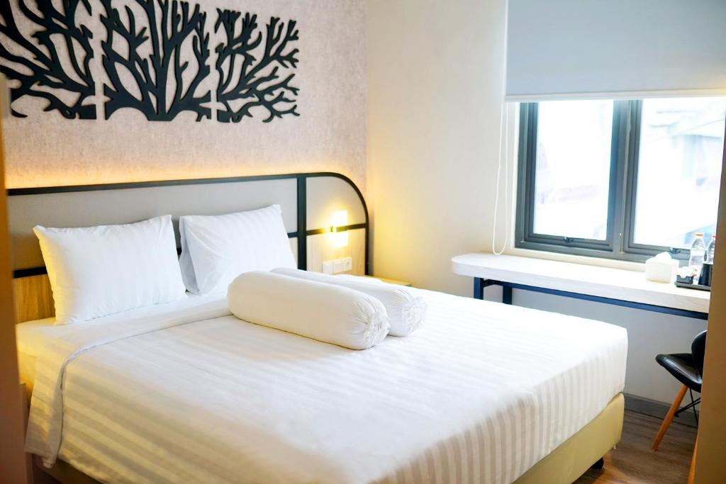 Postel nebo postele na pokoji v ubytování Front One Gosyen Hotel Salatiga