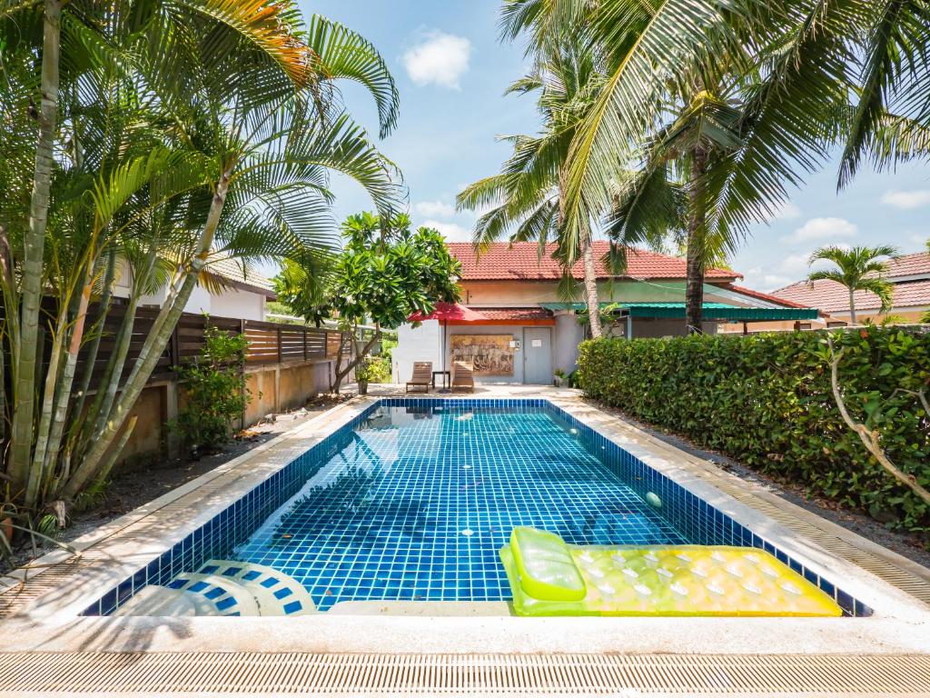 a swimming pool in front of a house with palm trees at Lemon House apartment in Koh Samui 