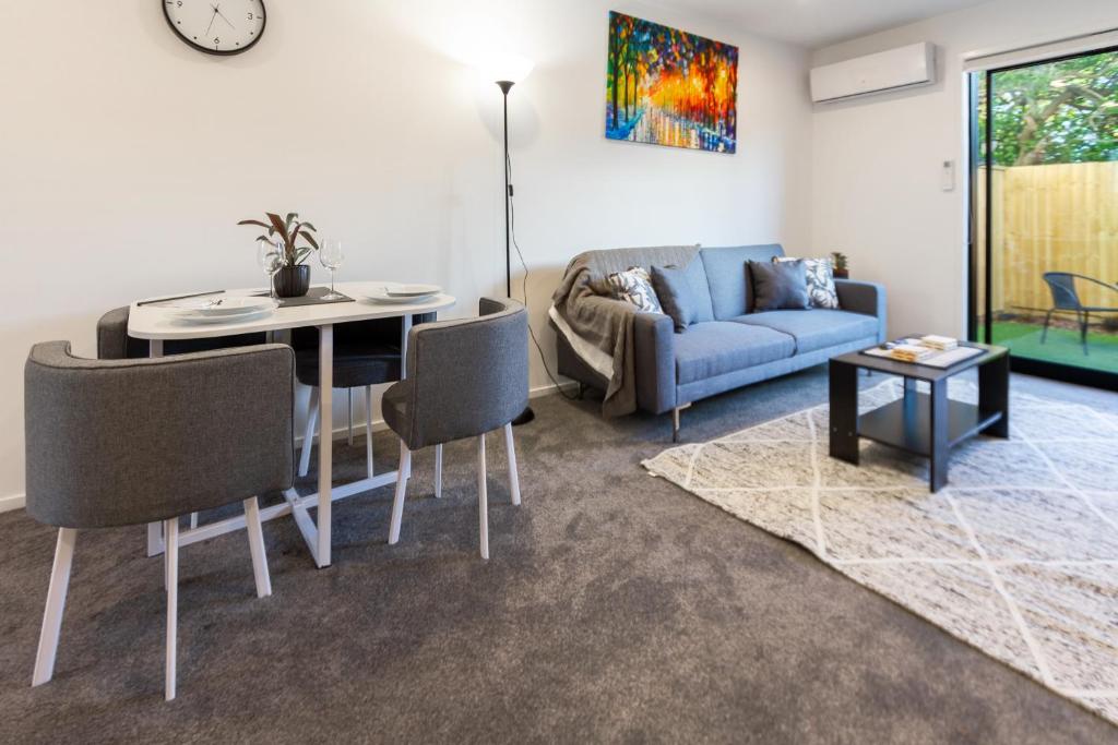 a living room with a blue couch and a table at Wave side escape 1 bed 1 bath, New Brighton in Christchurch