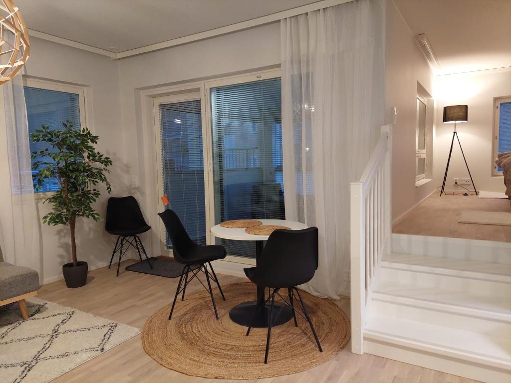 ein Wohnzimmer mit schwarzen Stühlen und einem Tisch in der Unterkunft Keskusta uusi kalustettu kaksio. in Kuopio