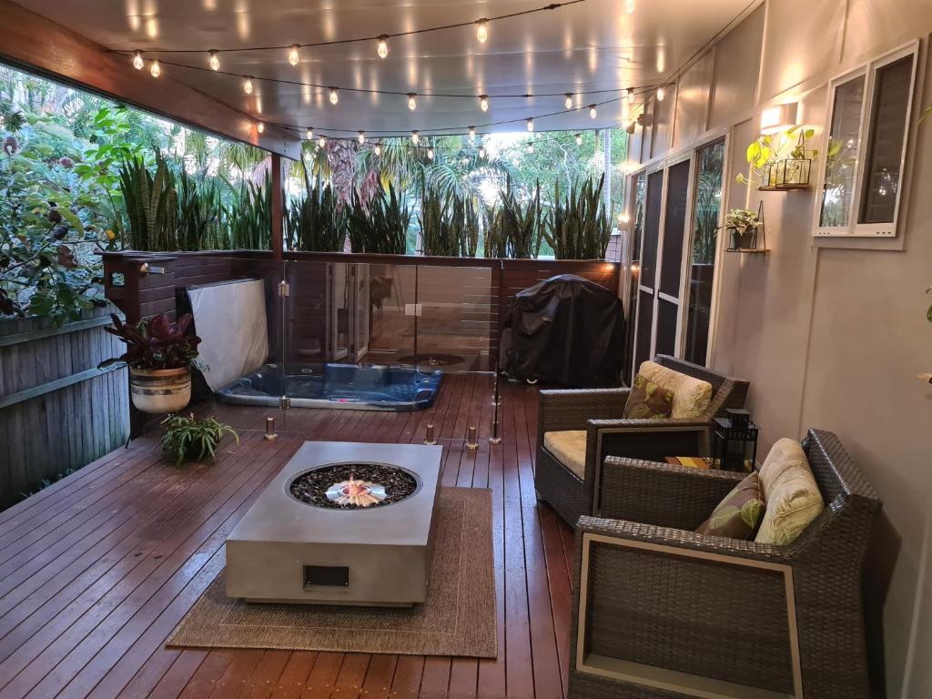 a screened in porch with chairs and a table at Pandanus Spa Cottage in Coolum Beach