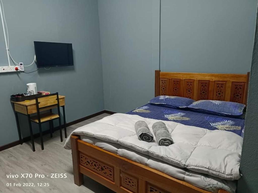 Un dormitorio con una cama, un escritorio y un televisor. en ROO STAy TOK WAN 1, en Kampong Nail