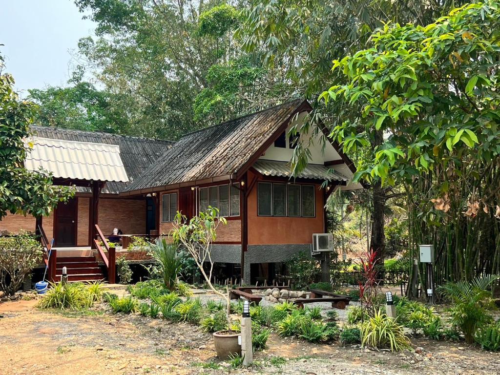 una casa en medio de un jardín en D.I.N @ทองผาภูมิ, en Ban Pracham Mai Bon
