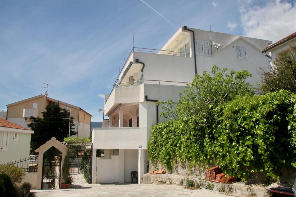 a large white house with a tree at Sea View Apartments in Herceg-Novi