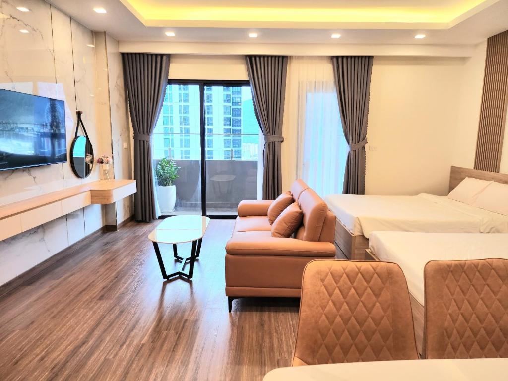 Cette chambre comprend un lit, un canapé et une télévision. dans l'établissement Quy Nhon City - FLC Sea Tower, à Quy Nhơn