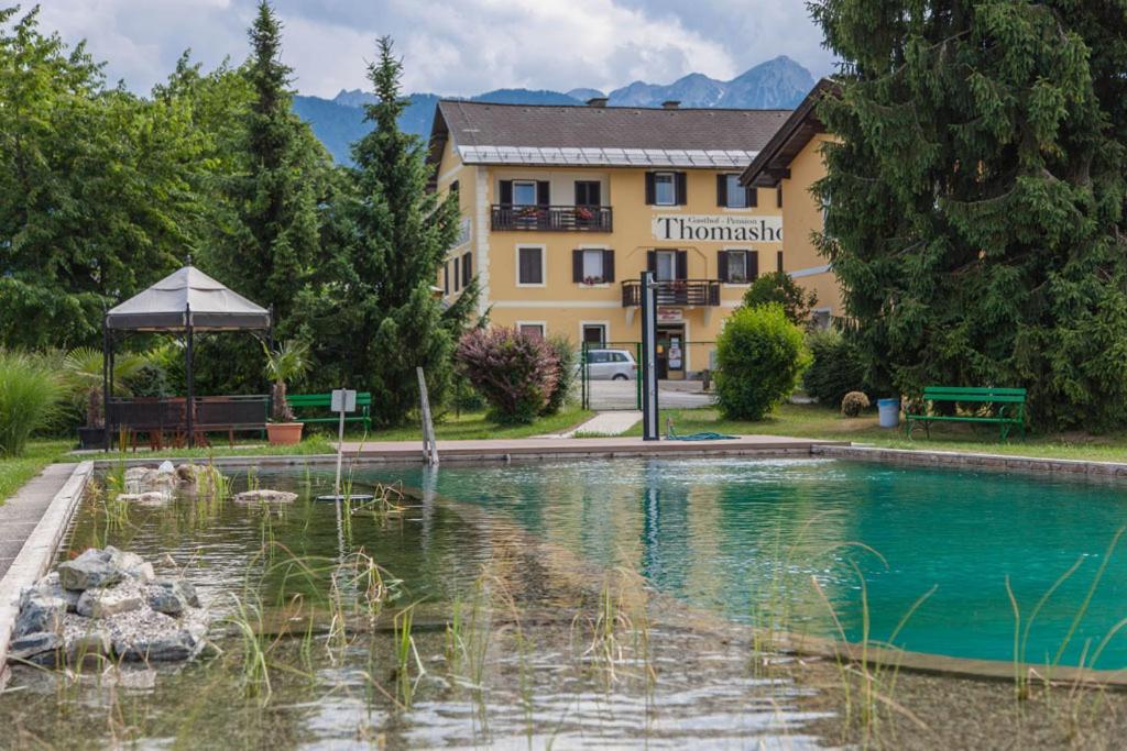 a hotel with a swimming pool in front of a building at Der Thomashof in Sankt Jakob im Rosental